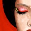 illustration of a woman with dark hair and eyes closed with a red background detail of the left eye