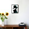 side profile illustration of a woman with a hat and coat that covers most of her face smoking a cigarette hanging on a wall in the living room