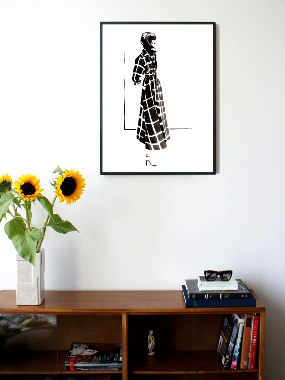 black and white illustration of a woman's side profile in a checkered long coat hanging on a wall in the living room