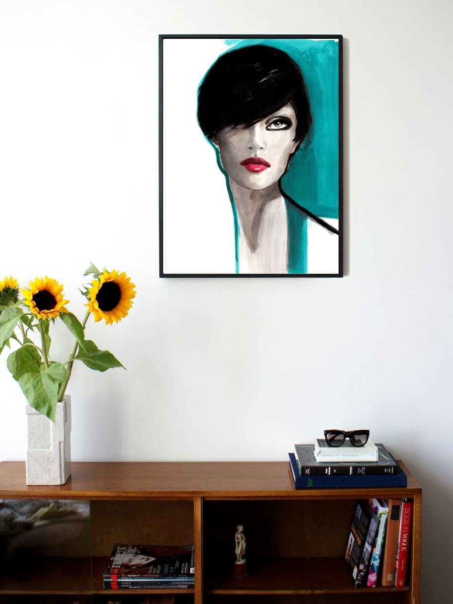 illustration of a woman with short dark hair and blue details hanging on a wall in the living room