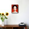 illustration of a woman with dark hair and eyes closed with a red background hanging on a wall in the living room