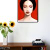 illustration of a woman with dark hair and eyes closed with a red background hanging on a wall in the living room