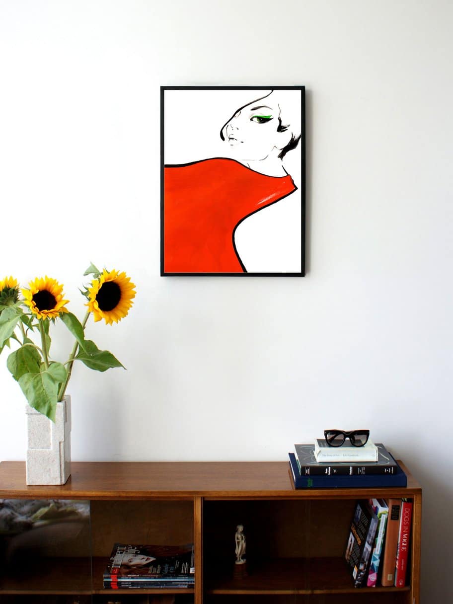 illustration of a womans face with a big red scarf around her neck hanging on a wall in the living room