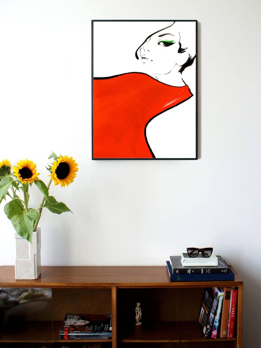 illustration of a womans face with a big red scarf around her neck hanging on a wall in the living room