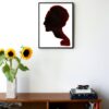 an illustration of a silhouette of the side of a womans face hanging on a wall in the living room