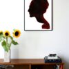 an illustration of a silhouette of the side of a womans face hanging on a wall in the living room