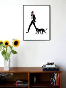 illustration of a woman in a suit walking with her dog next to her hanging on a wall in a living room