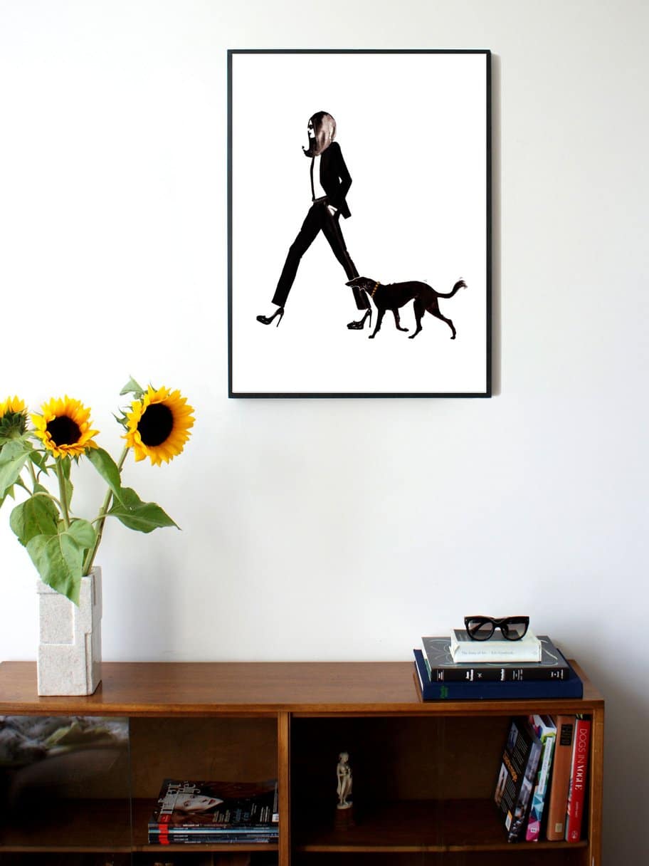 illustration of a woman in a suit walking with her dog next to her hanging on a wall in a living room