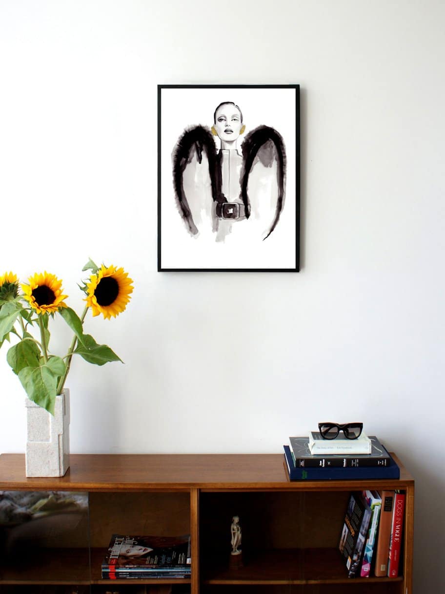 illustration in black and white of a woman with wings and golden earrings on a wall of a living room